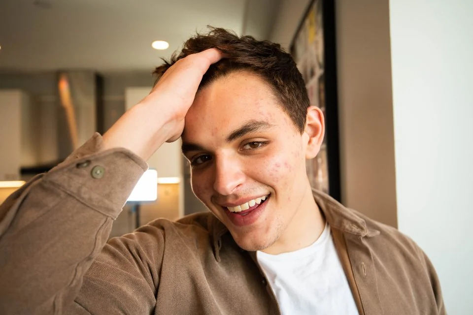 Smiling man running his hand through his hair