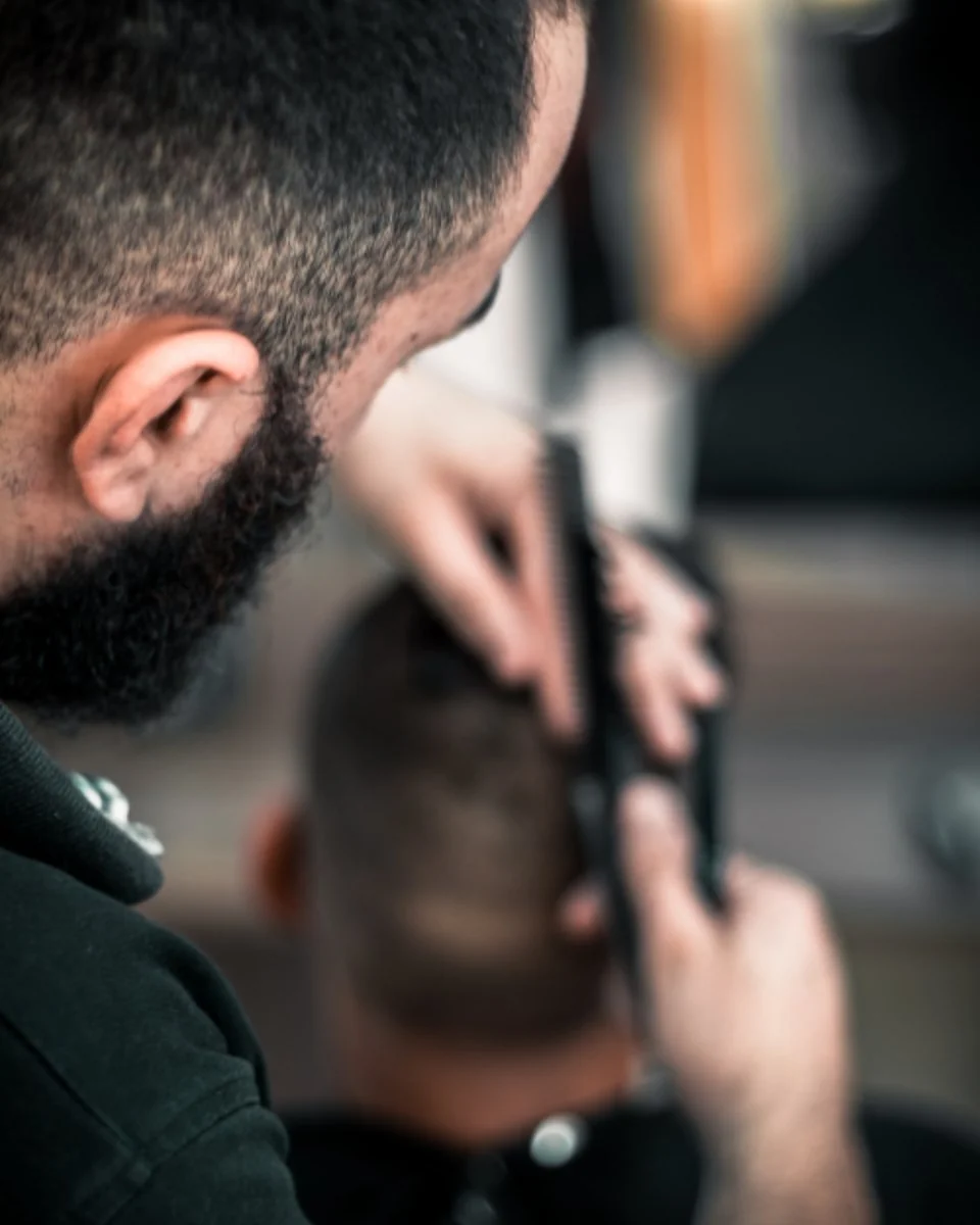 Barber trimming the back of a man's hair