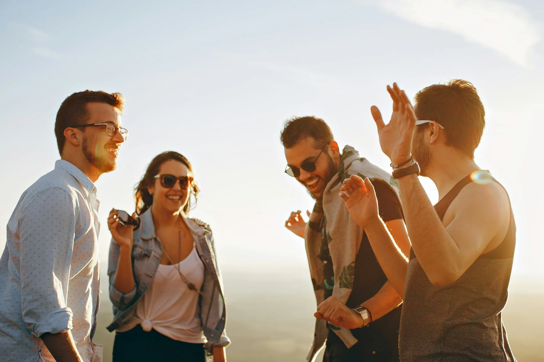 Friends laughing together outdoors at golden hour